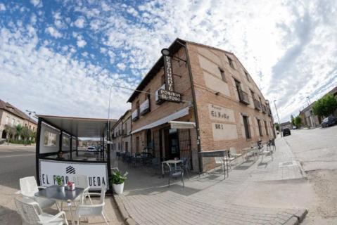 un edificio al lado de una calle con mesas y sillas en El Foro de Rueda, en Rueda