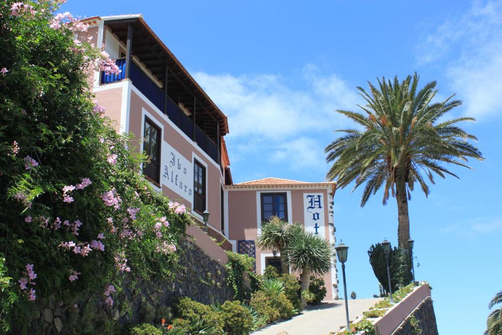 una casa con una palmera delante de ella en Hotel Rural Ibo Alfaro - OFFLINE HOTEL en Hermigua