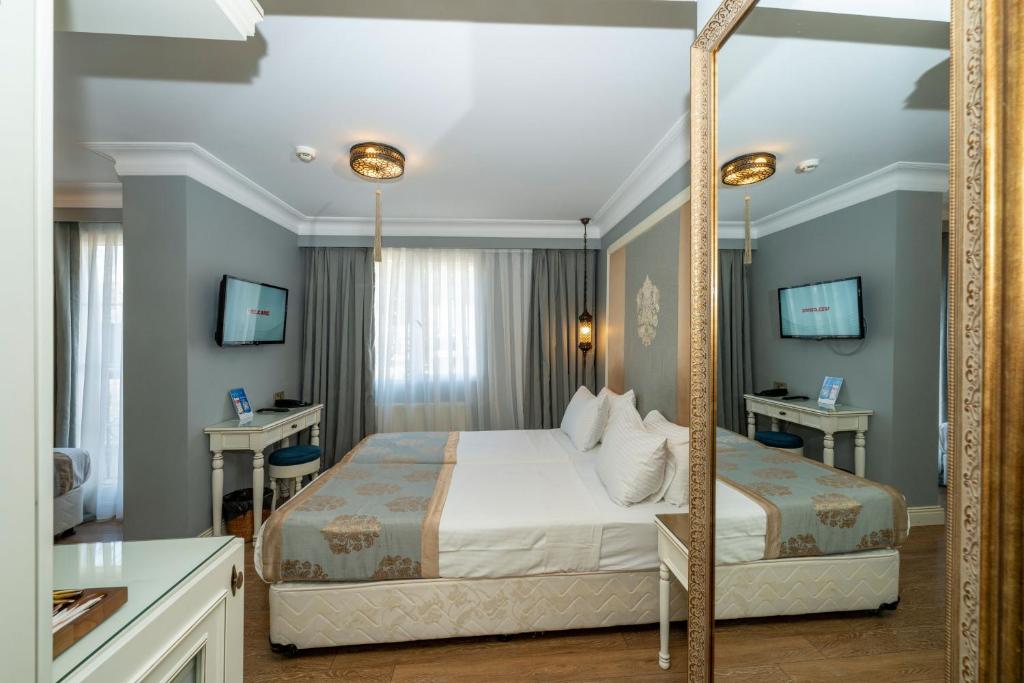 a bedroom with a bed and a large mirror at Raymond Blue Hotel in Istanbul