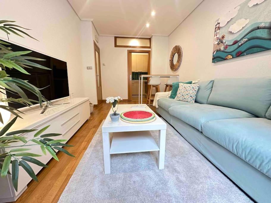 ein Wohnzimmer mit einem blauen Sofa und einem Tisch in der Unterkunft Luxury Centro de Vigo Balcony in Vigo