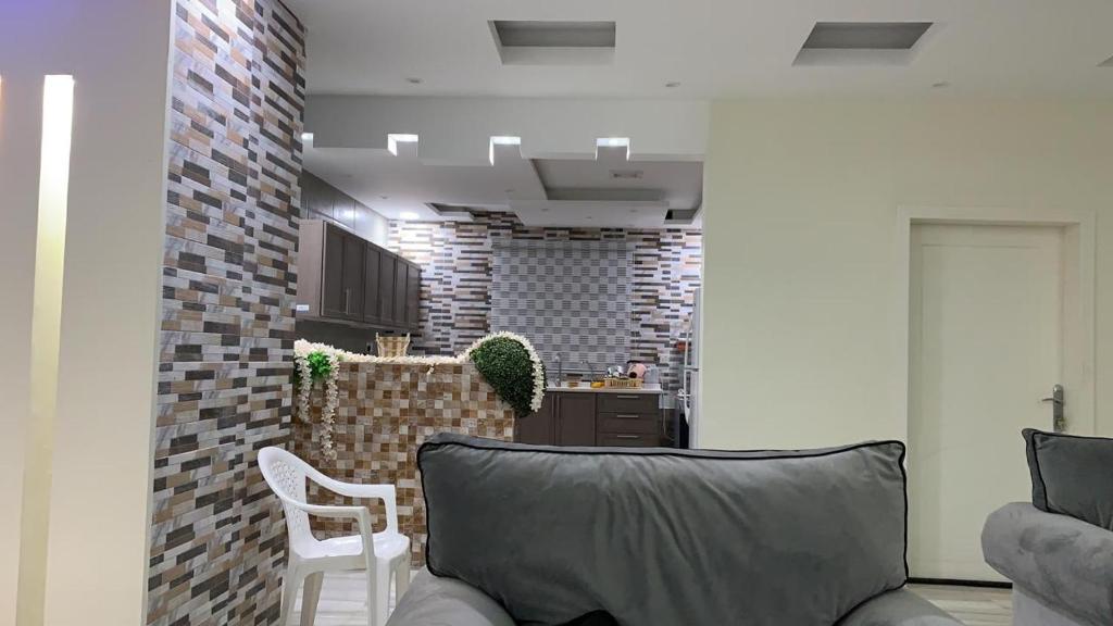 a living room with a couch and a brick wall at صلاح ليما -1 in Dammam