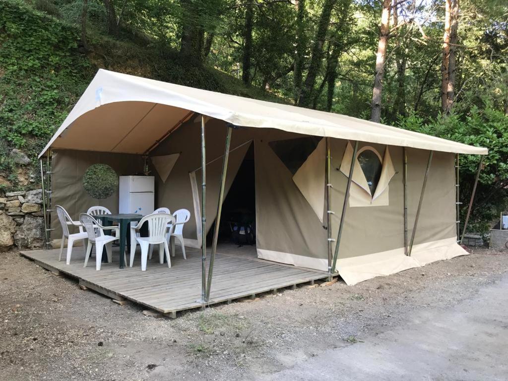 a tent with a table and chairs in it at Camping Les Fines Roches in Roquestéron