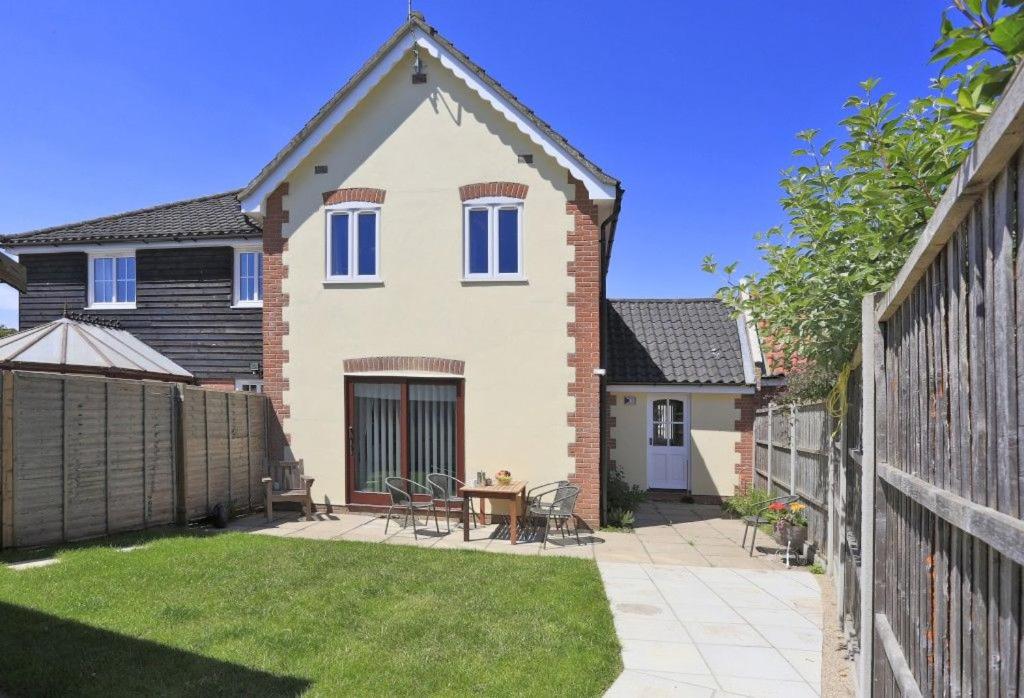 a house with a patio and a fence at Sparrows, Wangford nr Southwold in Wangford