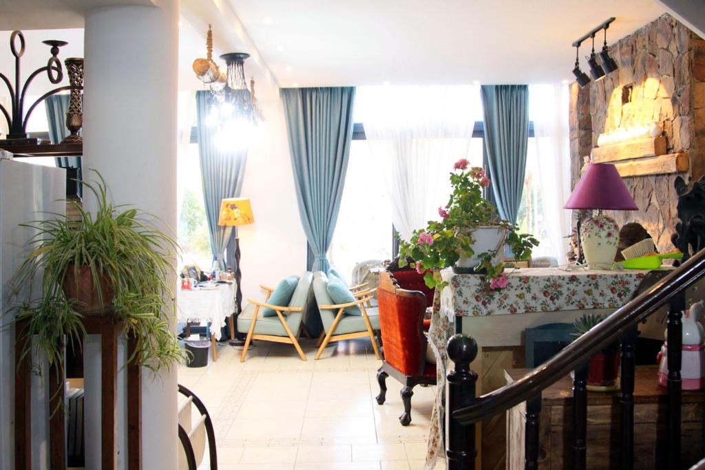 La Maison du Laoshay Lijiang في ليجيانغ: غرفة معيشة مع ستائر زرقاء وطاولة