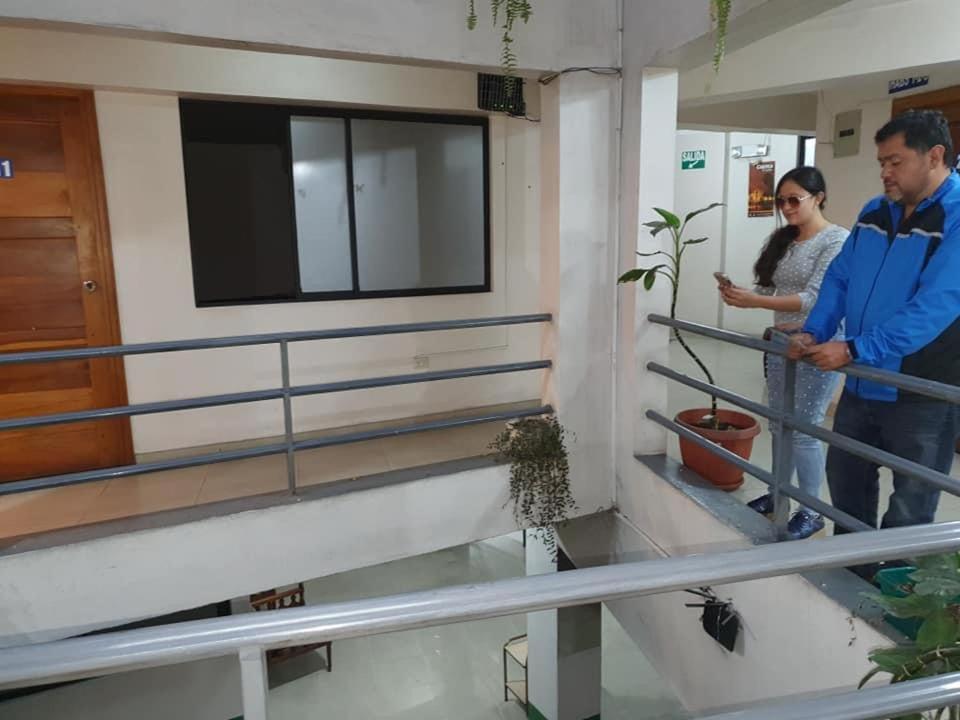 twee mensen op de trap van een gebouw bij Hospedaje Fenix in Cuenca
