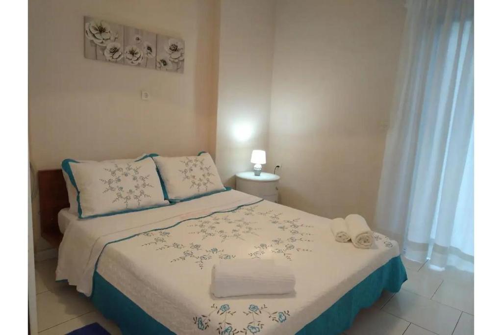um quarto com uma cama com lençóis azuis e brancos em Olga Studios em Heraclião