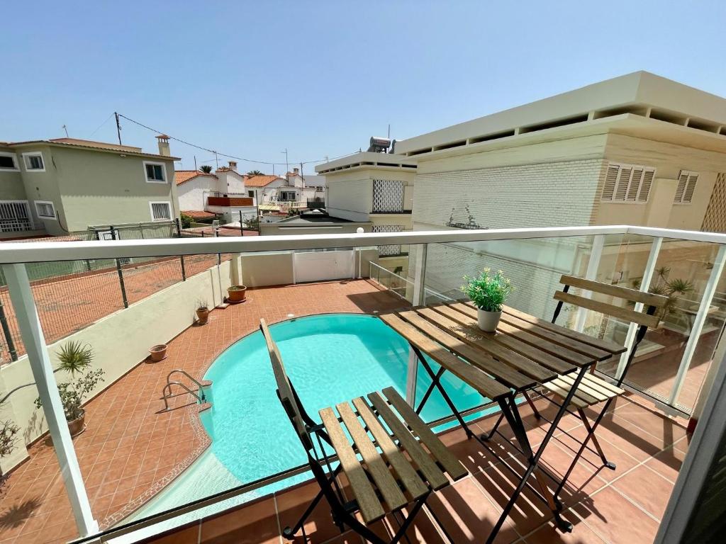 a balcony with a table and chairs and a swimming pool at Apartamento Deluxe Ciudad Jardin in Las Palmas de Gran Canaria
