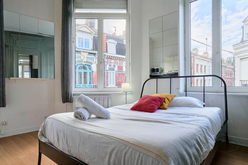 a bed in a room with a large window at Lille Saint Maurice - Nice and functional studio in Lille