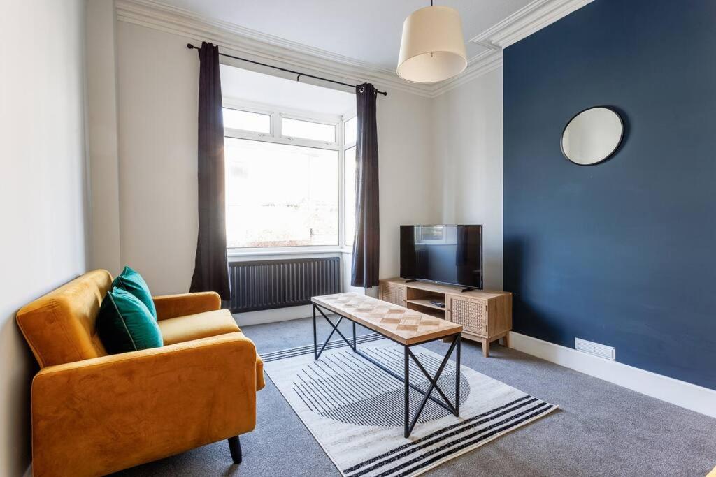 uma sala de estar com um sofá, uma mesa e uma televisão em 3 BR home perfect for big groups em Darlington