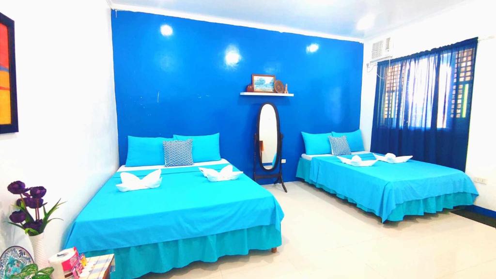 Duas camas num quarto com paredes azuis em Bjh em Pagudpud