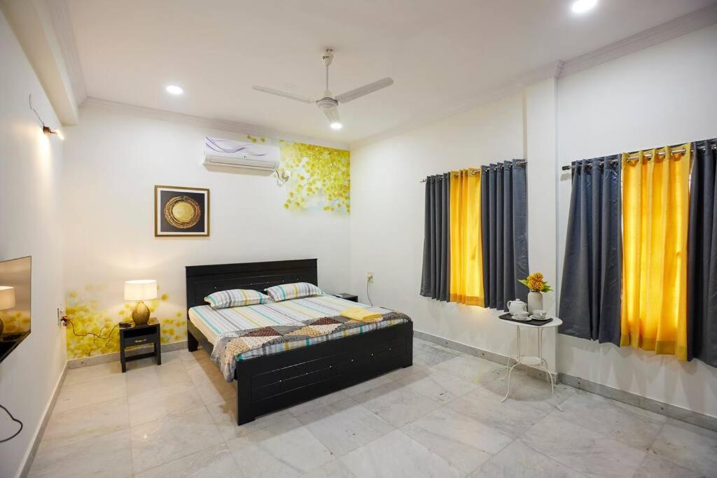 een slaapkamer met een bed en gele en blauwe gordijnen bij Legend's studio room with Mini kitchenette in Hyderabad