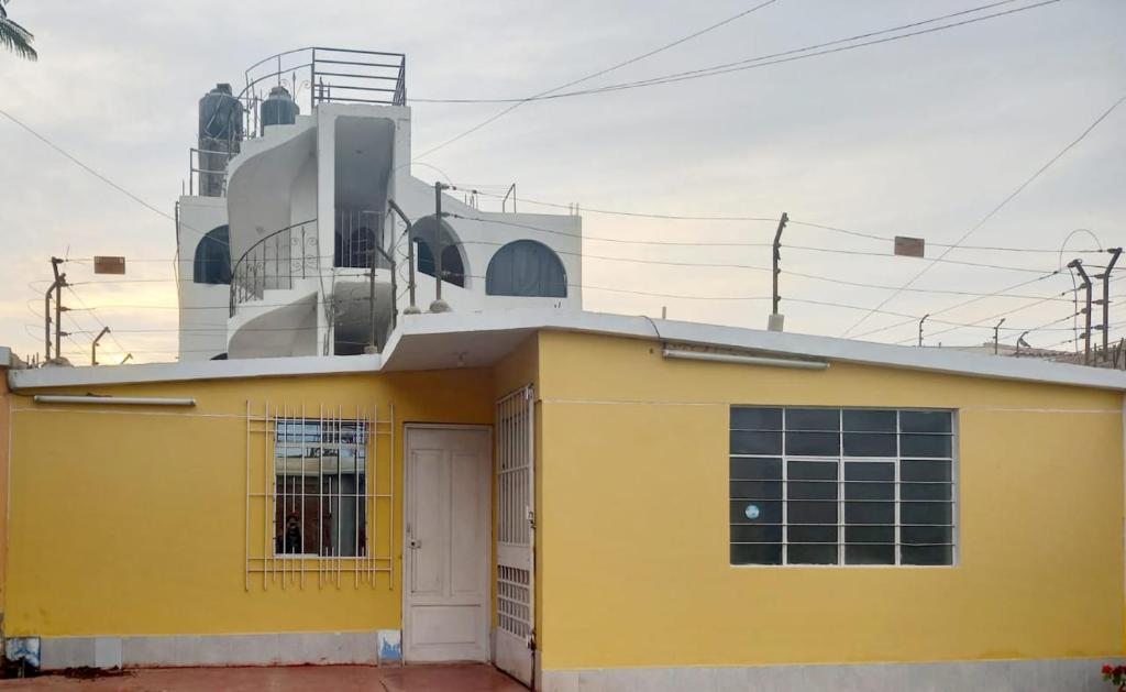 un bâtiment jaune avec une porte devant lui dans l'établissement Posada de Mary, à Pisco