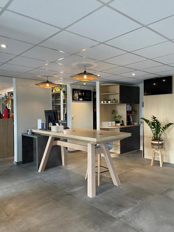 una gran mesa de madera en una habitación con una mesa en ibis Laon, en Laon