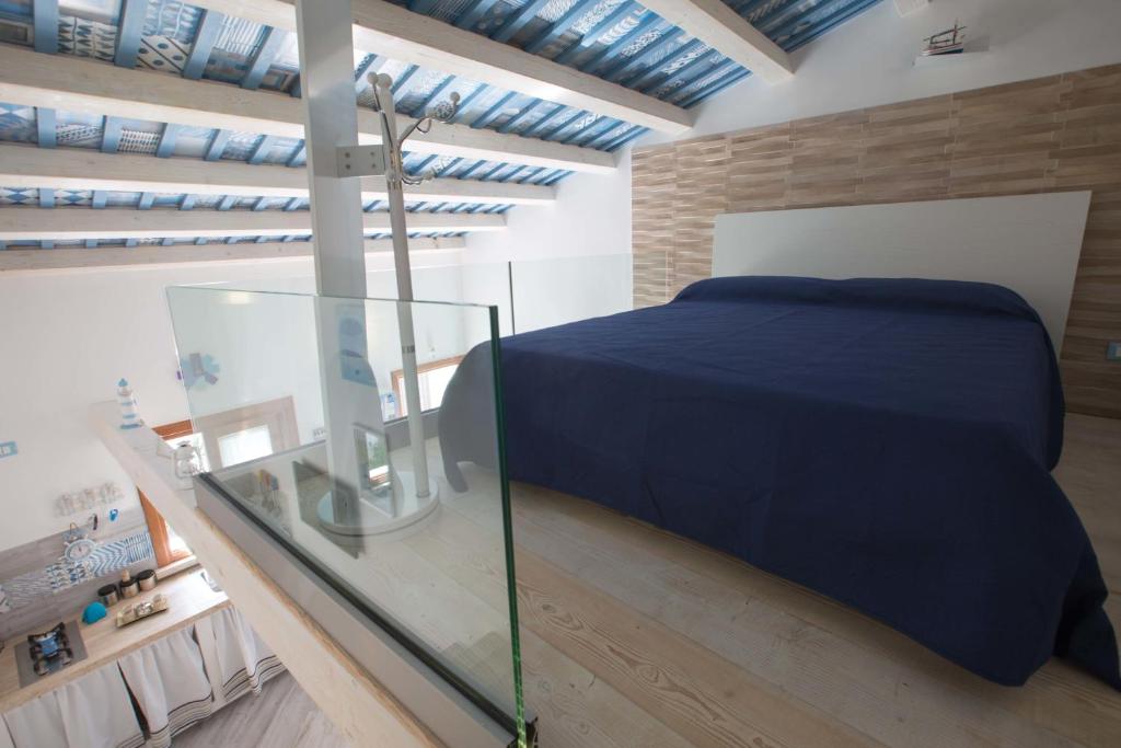 Schlafzimmer mit einem Bett und einem Glastisch in der Unterkunft La Casetta nel Porto in Castellammare del Golfo