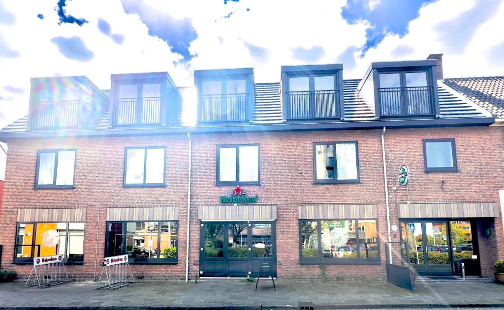 un edificio de ladrillo rojo con ventanas y balcones. en Eetcafé Punt, en Roelofarendsveen