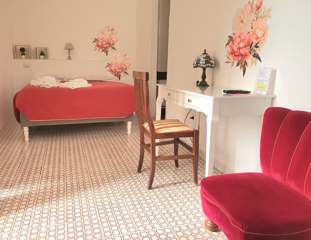 ディアマンテにあるIl MOLO Camere per vacanzeのベッドルーム1室(ベッド1台、椅子、デスク付)