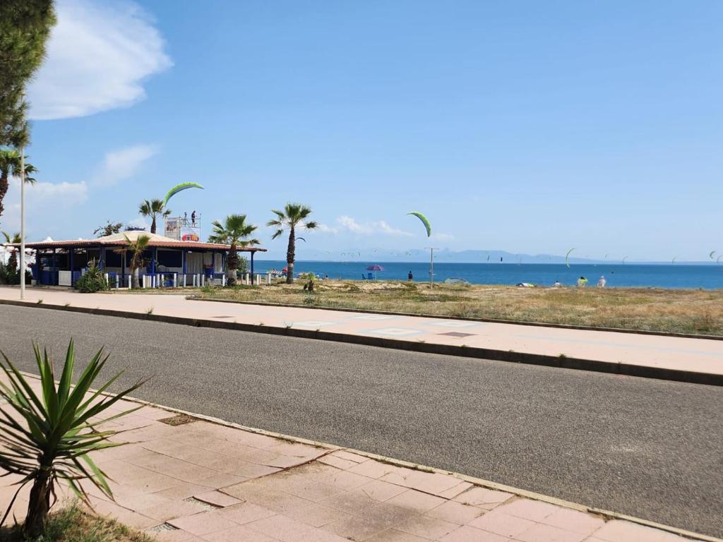 une route vide à côté d'une plage bordée de palmiers dans l'établissement Figu Morisca Silì, à Silì