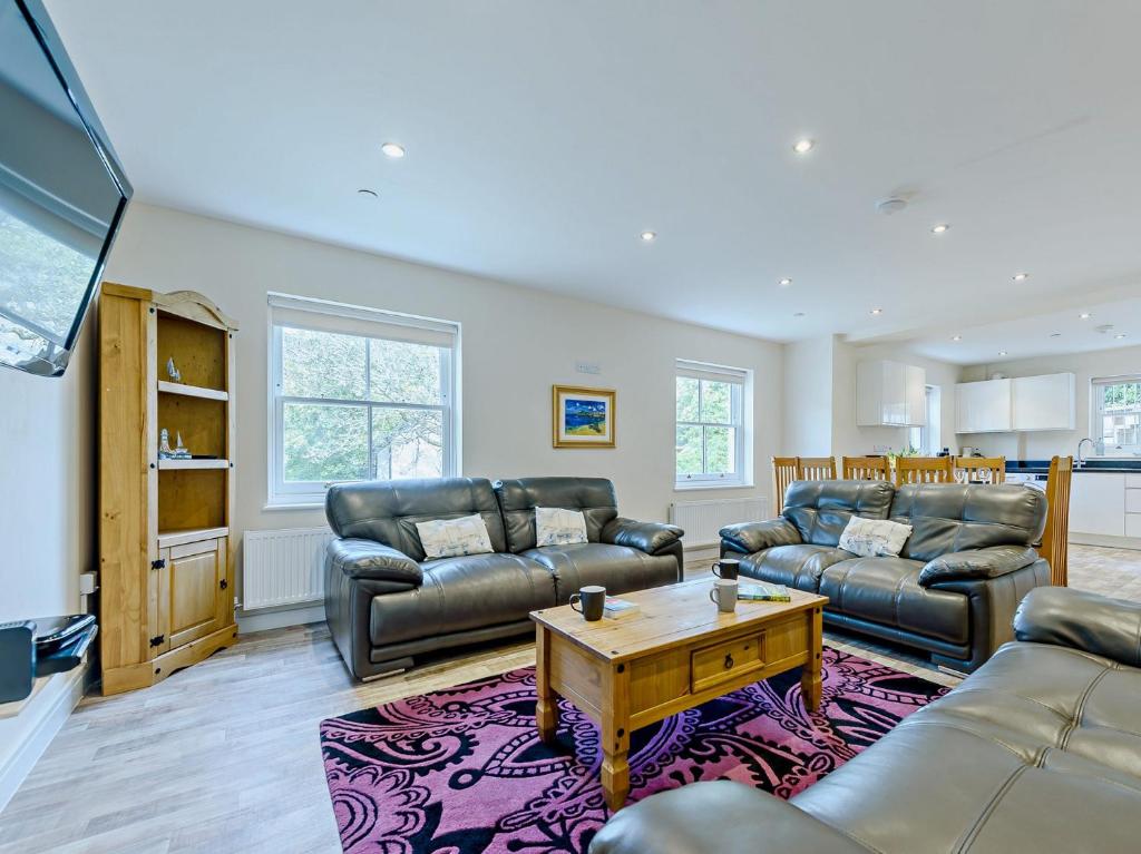 a living room with two couches and a coffee table at 4 Bed in Tenby FB270 in Tenby