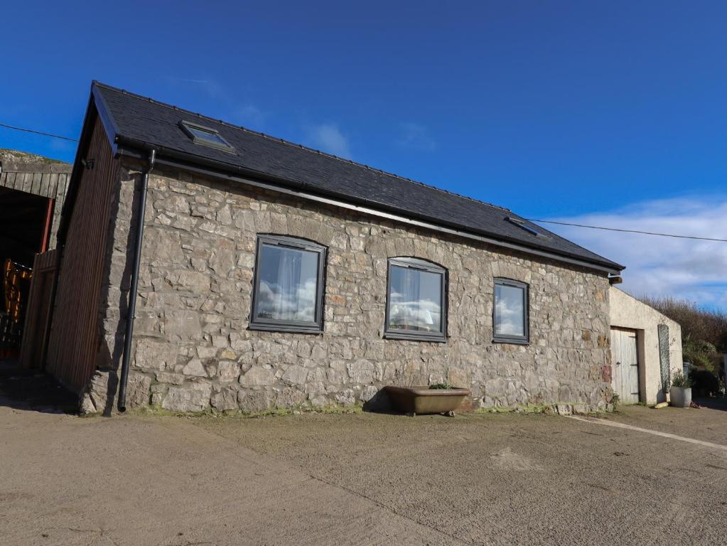 a stone building with three windows on the side of it at The Old Parlour in Rhyl