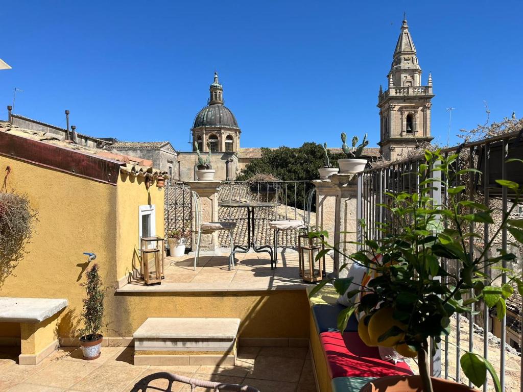 einen Balkon mit Blick auf ein Gebäude mit einem Uhrturm in der Unterkunft B&B Sangiovanni in Ragusa