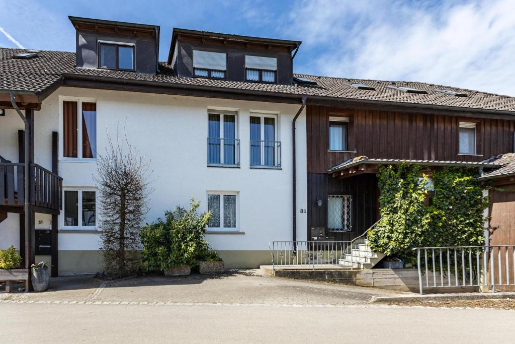 a large white house with blue windows at Ferienwohnungen Martin Lafar in Öhningen