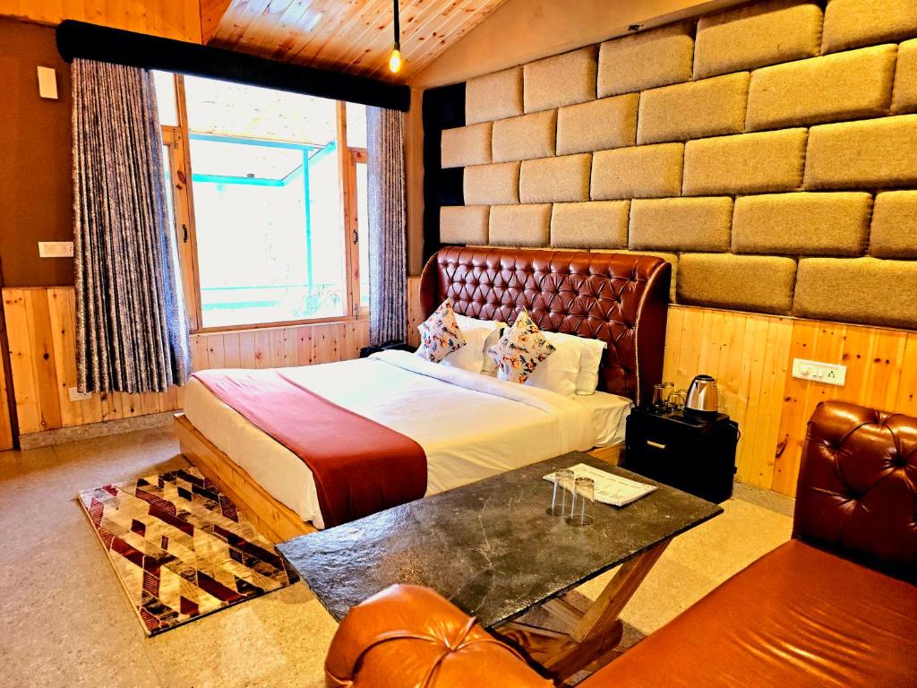 a bedroom with a bed and a table and a couch at Hotel Old Manali with Balcony and Mountain Views, Near Manali Mall Road in Manāli