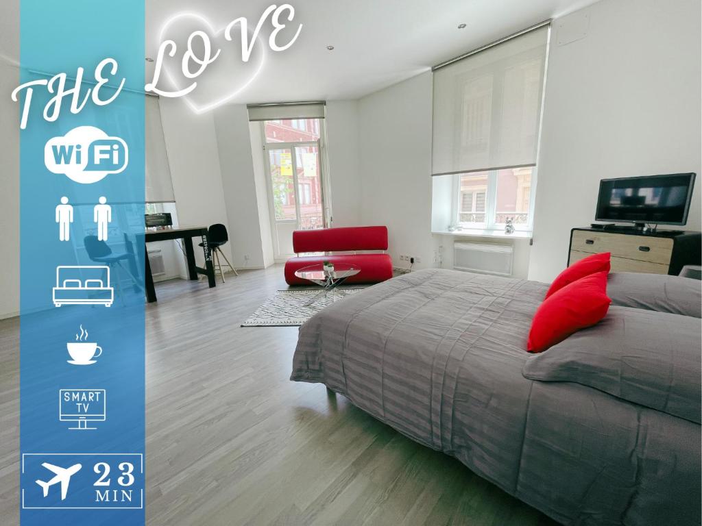 une chambre avec un lit et une chaise rouge dans l'établissement The Love intimité au cœur du centre-ville, à Mulhouse