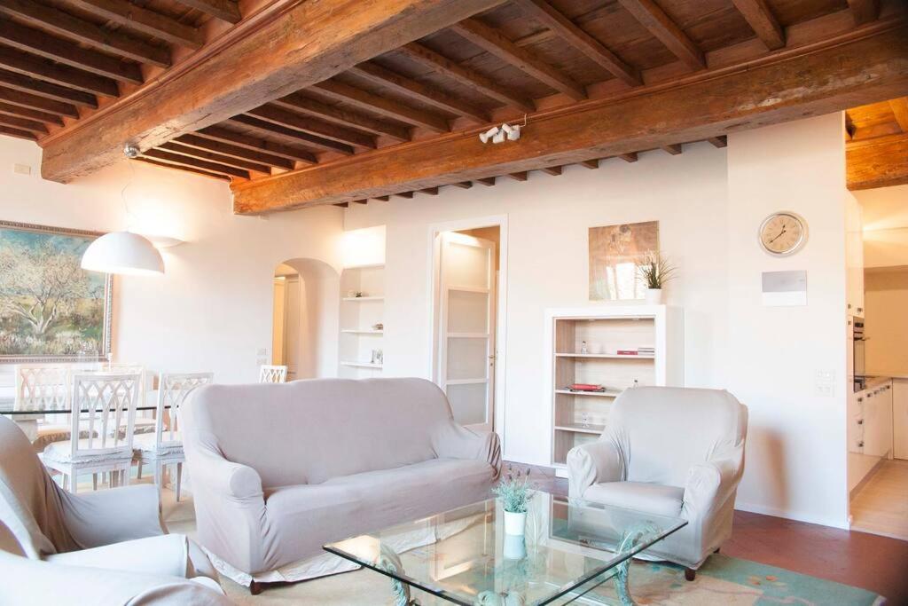 ein Wohnzimmer mit 2 Stühlen und einem Glastisch in der Unterkunft Tornabuoni Charming Apartment in Florenz