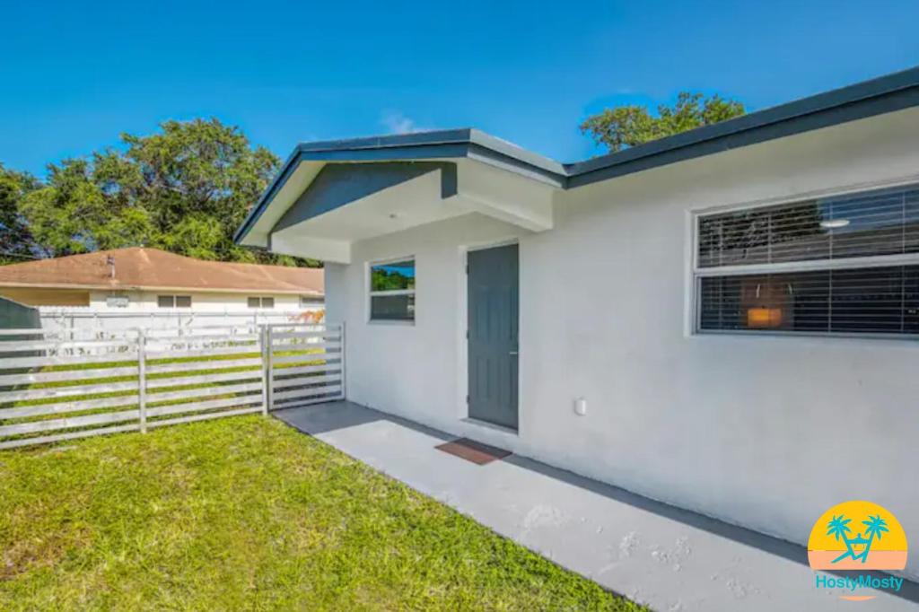 une maison blanche avec clôture et pelouse dans l'établissement Gated 2Bd 1Bth Design Dist 10-Min to Beach - 5037, à Miami