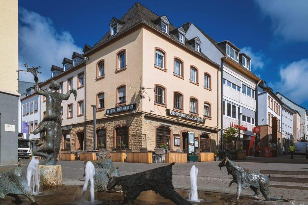 un edificio con una fuente frente a un edificio en Hotel Louis Müller, en Bitburg