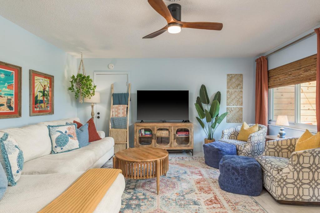 een woonkamer met een bank en een tv bij Luxury Home with Hot Tub & Outdoor Oasis blocks from the Beach in St Pete Beach