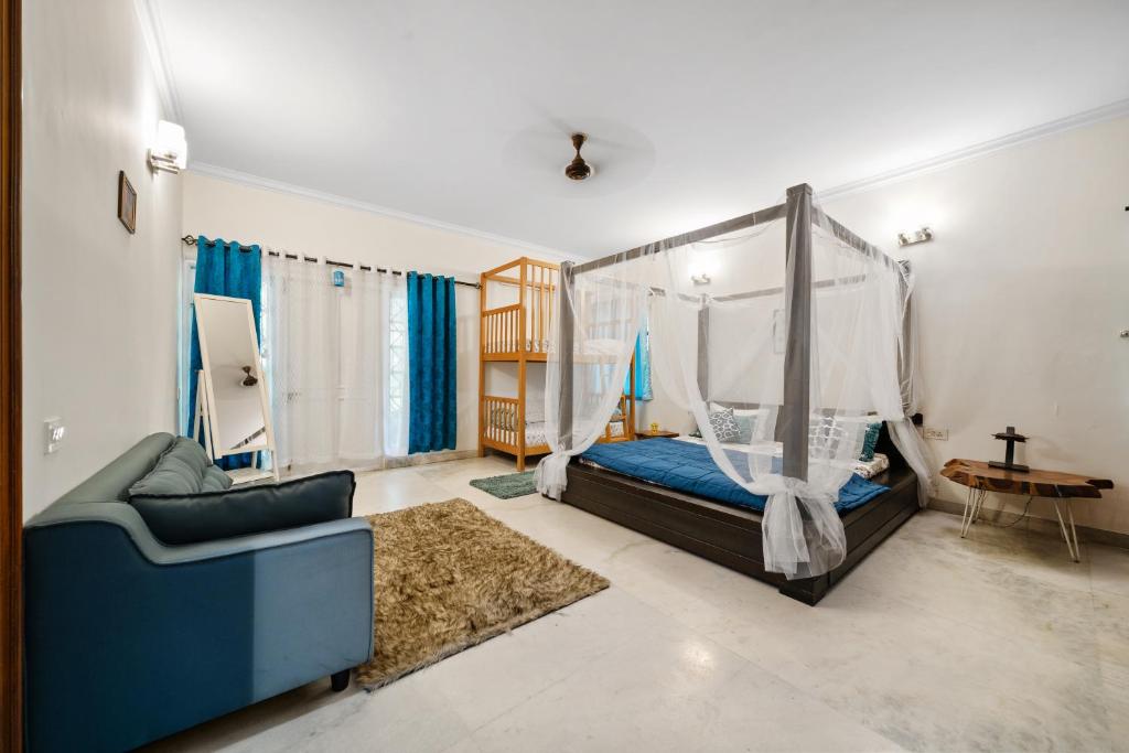 um quarto com uma cama e um sofá azul em Ocean Oasis em Bangalore