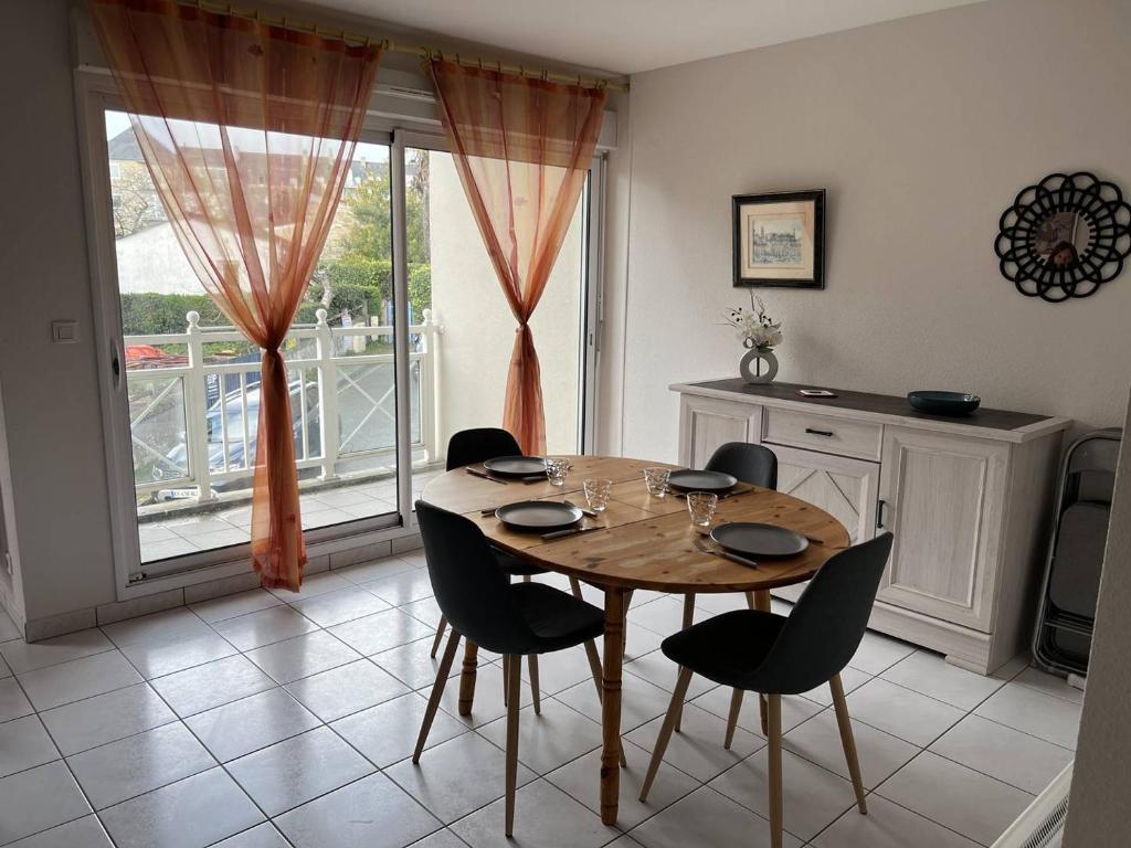 une salle à manger avec une table et des chaises en bois dans l'établissement Appartement T3 Duplex Saint Cast Le Guildo, à LʼIsle-Saint-Cast