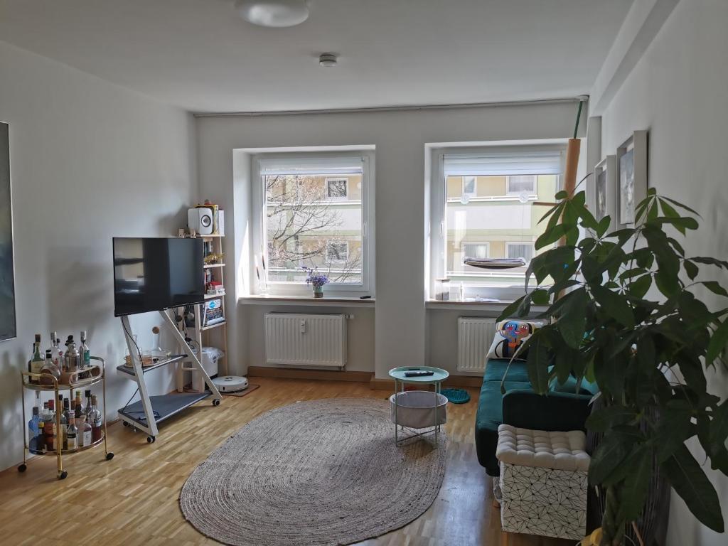 a living room with a couch and a potted plant at Center Schwabing Spacious flat in Munich