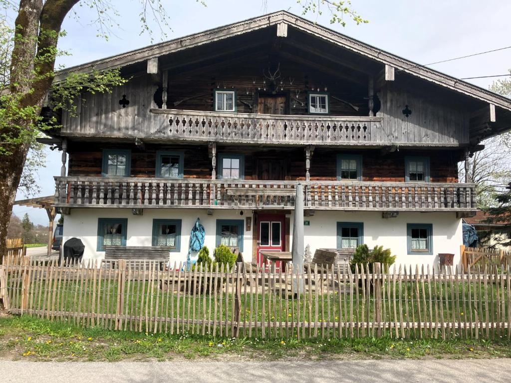 ein altes Holzhaus mit einem Zaun in der Unterkunft Bauernhaus Untermoos in Breitenbach am Inn