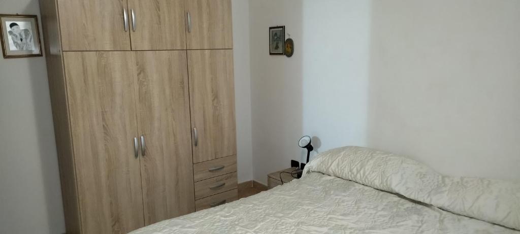 a bedroom with a large wooden cabinet next to a bed at Taverna Cristina in Porto Torres