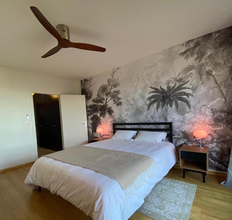 a bedroom with a large bed and a ceiling fan at Horizon sur le Cher in Montrichard