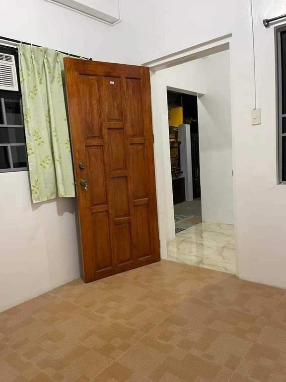 ein leeres Zimmer mit Holztür und Flur in der Unterkunft RYO3 in Davao City