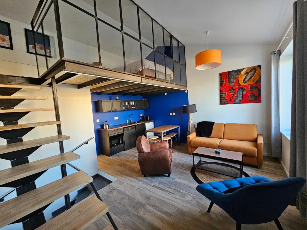 a living room with a staircase and a couch at Les Voyages du Loft, entre Eurexpo et St Exupéry in Genas