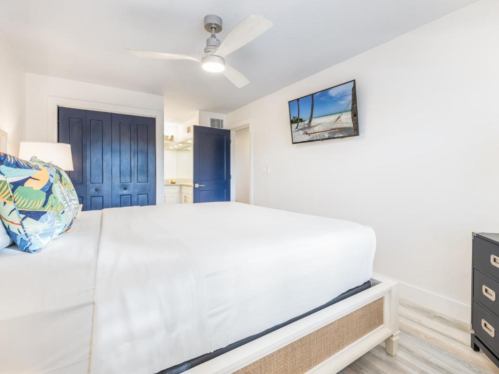 a bedroom with a white bed and a tv at South Seas Resort - Official Site in Captiva
