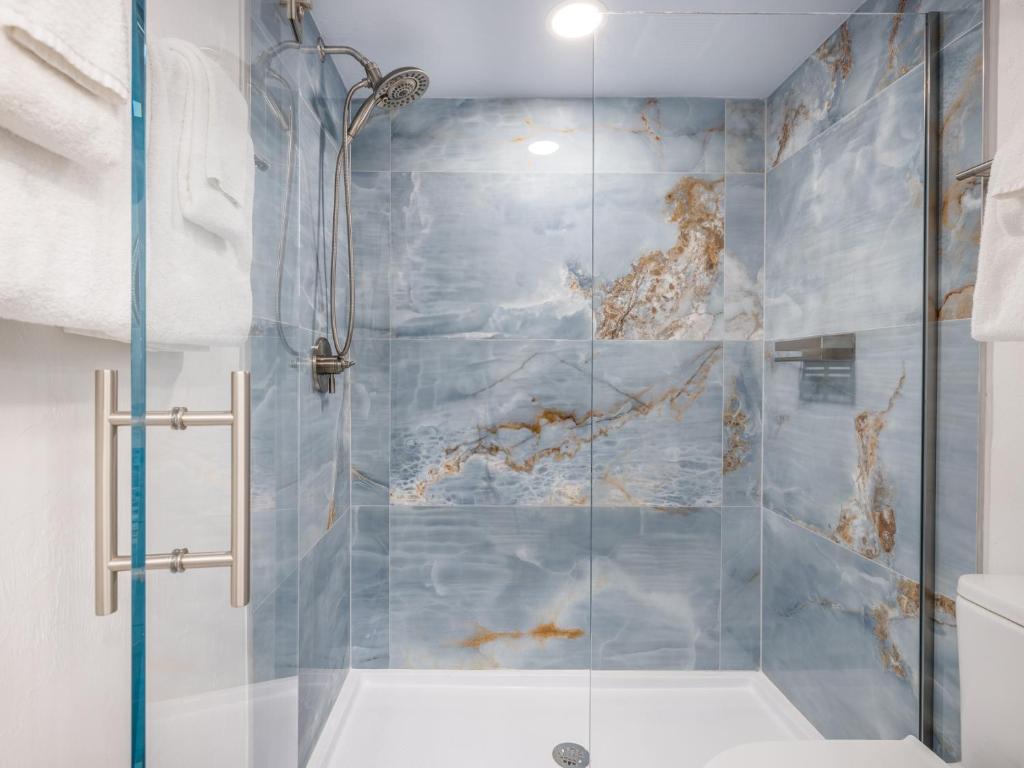a bathroom with a shower with blue tiles at South Seas Resort - Official Site in Captiva