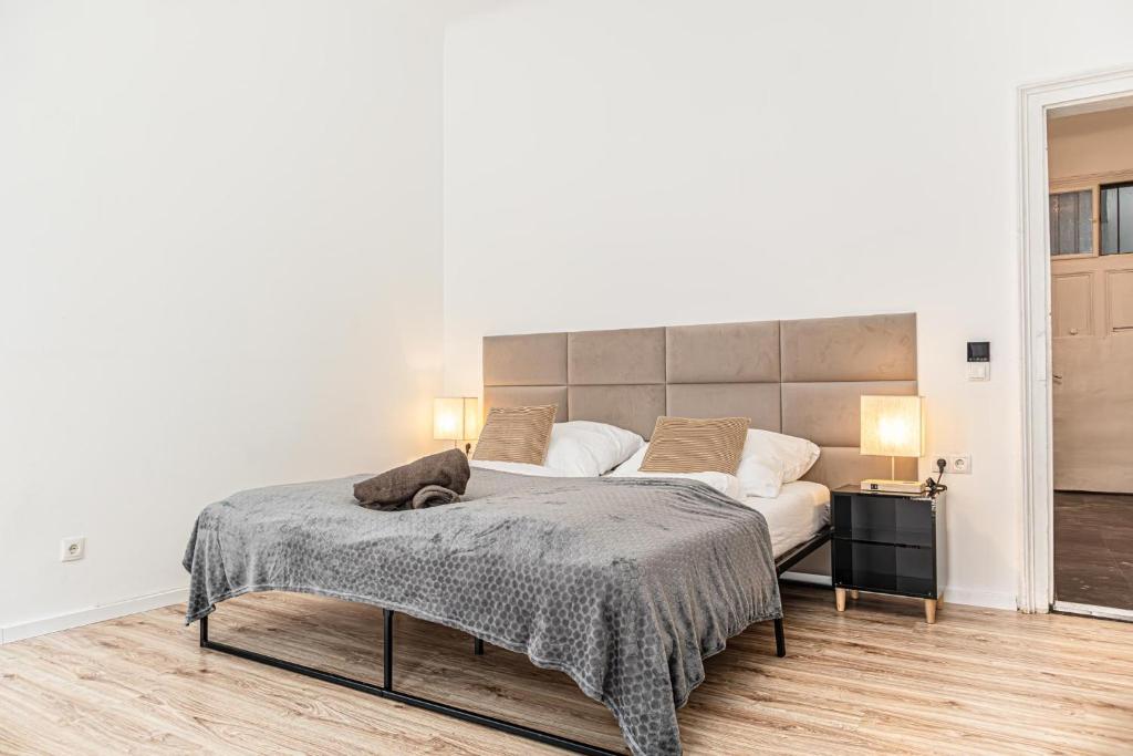een slaapkamer met een groot bed met een groot hoofdeinde bij Past Meets Present - 1BR Apt near Westbahnhof in Wenen