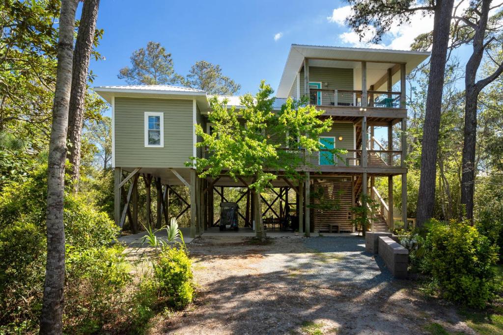 a house in the woods with a balcony at The TreeHouse by the Sea in Carolina Beach