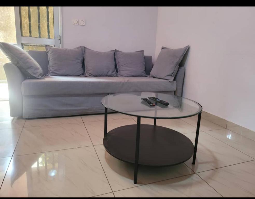 ein Wohnzimmer mit einem Sofa und einem Glastisch in der Unterkunft Résidence privée in Conakry