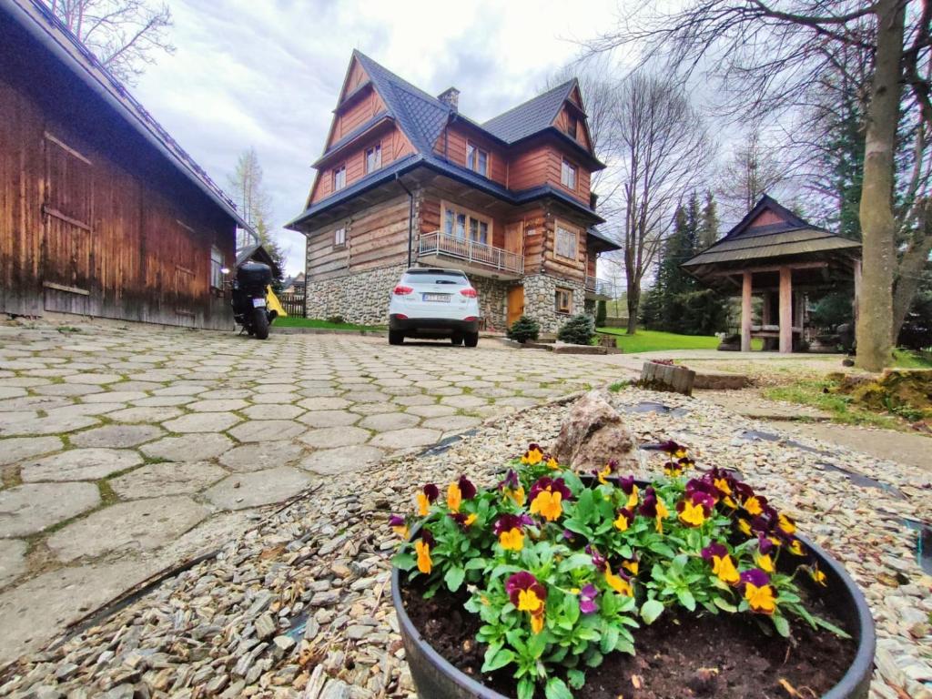 a house with a pot of flowers in front of it at Dom Wczasowy u Gruszki in Dzianisz