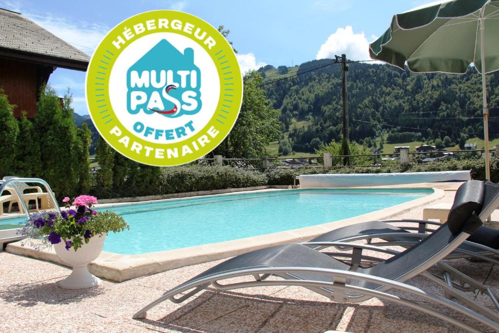 a swimming pool with two chairs and a sign at Julianna , appartements avec services gratuits in Morzine