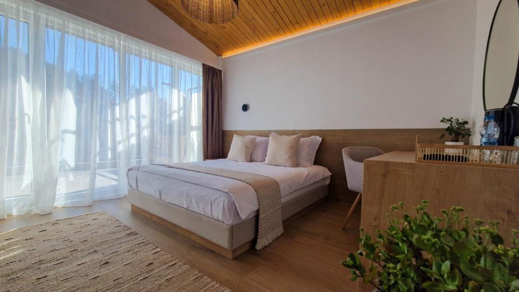 a bedroom with a bed and a large window at Waterside SPA Hotel in Ognyanovo