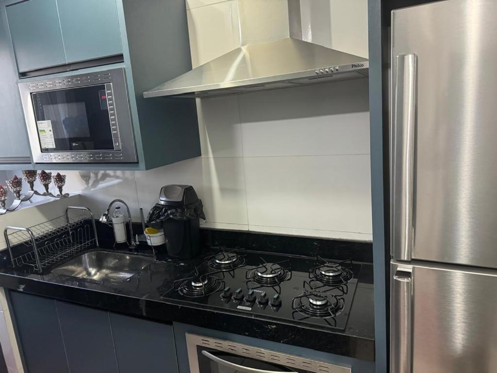 a kitchen with a stove and a stainless steel refrigerator at ALUGUEL TEMPORADA TECNOSHOW in Rio Verde