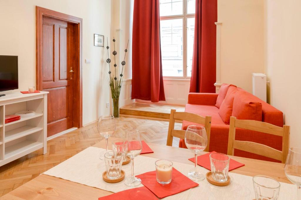 Stella apartments في براغ: غرفة معيشة مع طاولة مع كؤوس للنبيذ عليها