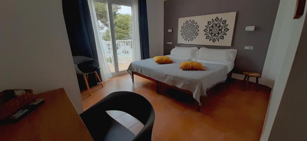 a bedroom with a bed with two yellow pillows on it at Hostal Bahía Azul in Portocolom